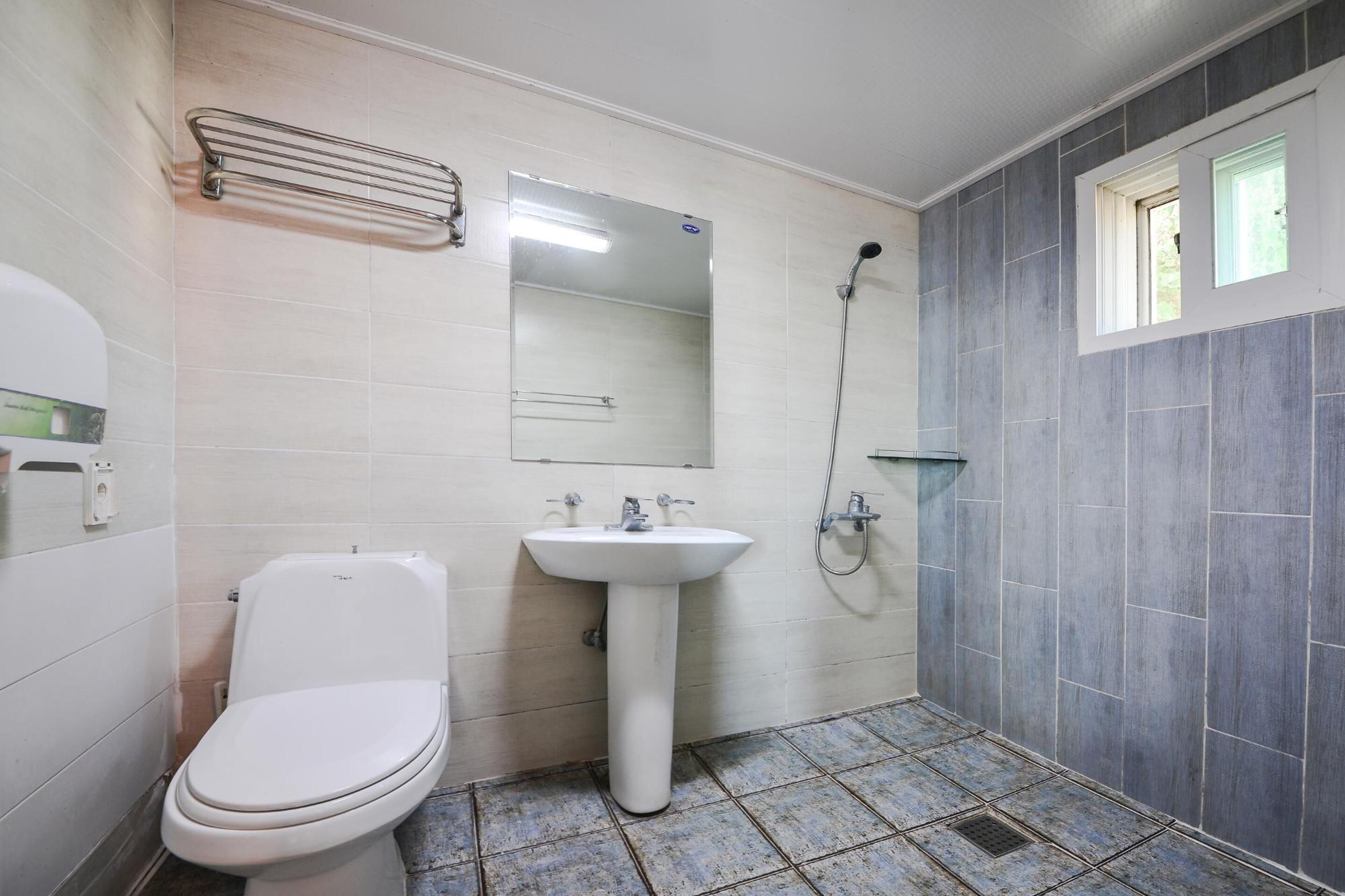A bathroom with a toilet, sink, and shower.