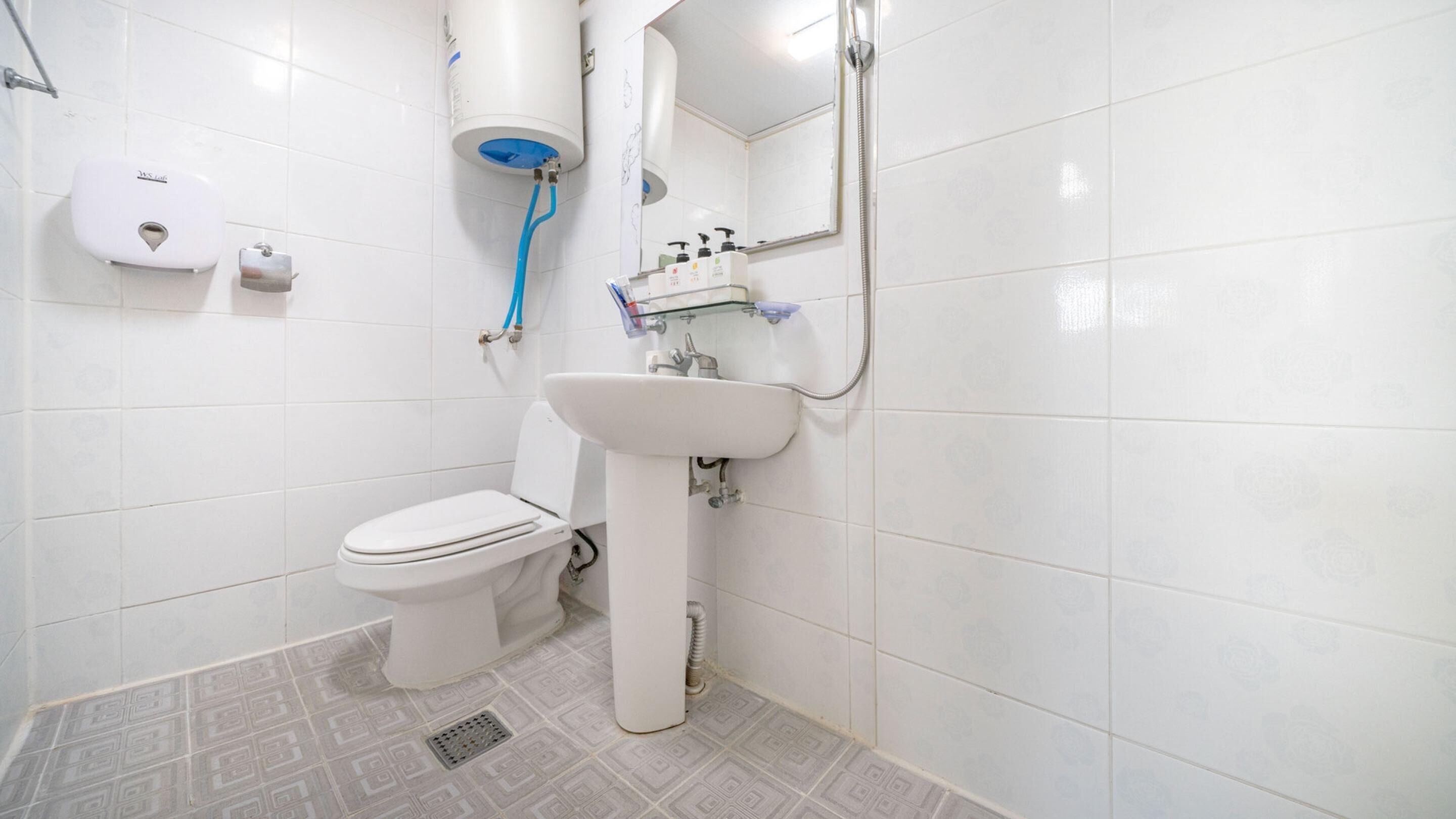 A bathroom with a toilet, sink, and shower.