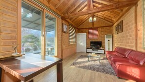 A wooden cabin interior with a sofa, TV, and a dining table. - Gapyeong Ebenzer Pension (Gapyeong)