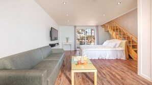 A modern bedroom with a wooden staircase, a sofa, a bed, and a small table with a tray. - The Gangneung Foret Pension (Gangneung)