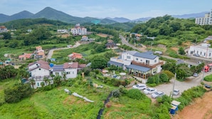 Vista aérea de una zona residencial con casas, una carretera y una montaña al fondo.