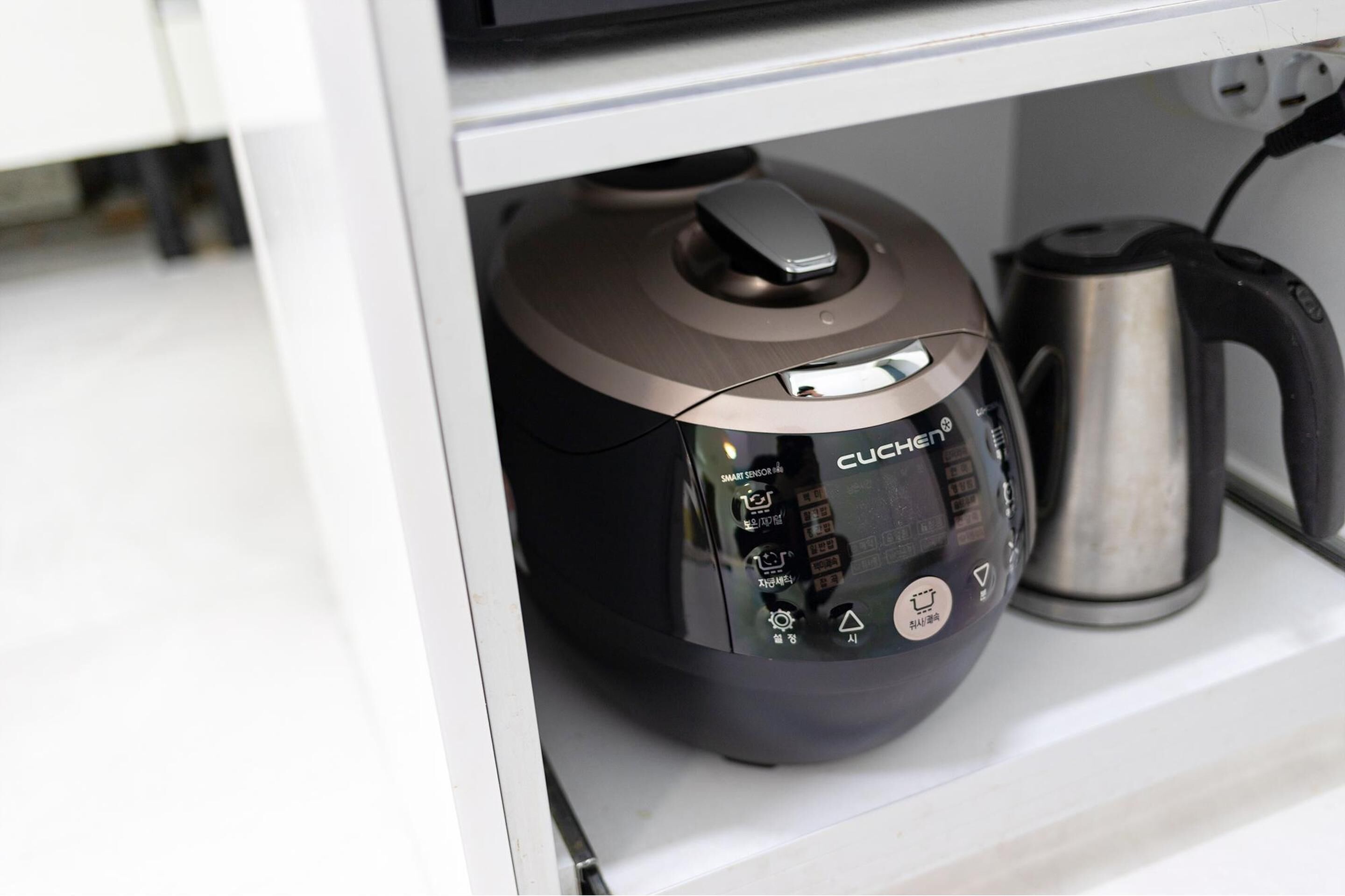 A kitchen with a modern coffee maker and a kettle.