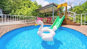 Ein Swimmingpool mit Schwimmschwan und Rutsche.
