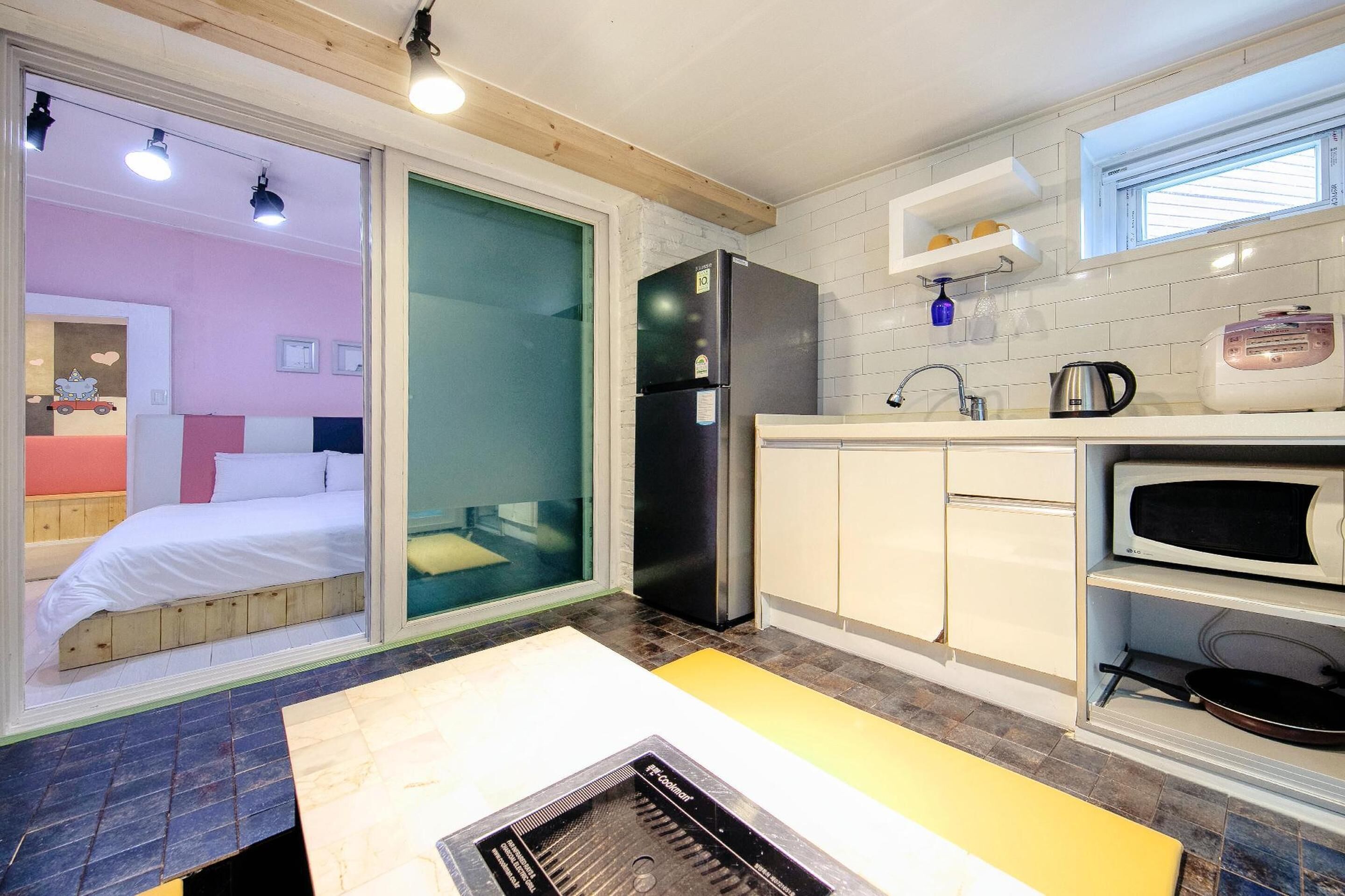 A compact kitchen with a refrigerator, microwave, and sink.