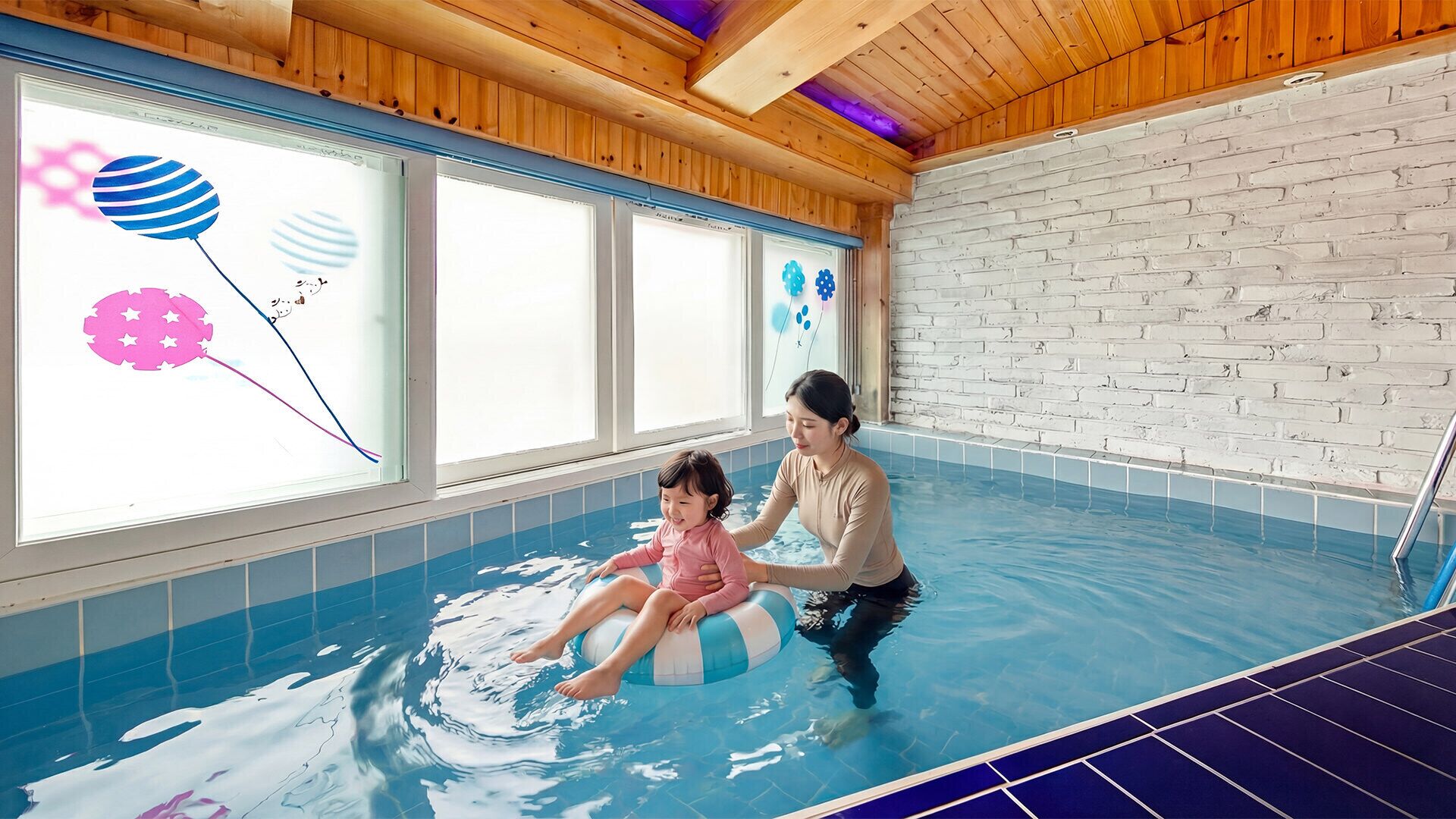 An indoor swimming pool with wooden ceiling beams, a brick wall, and a window with a view of balloons.
