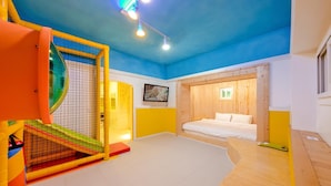 Ein Zimmer mit einem Bett, einem Spielbereich und einer Holzwand.