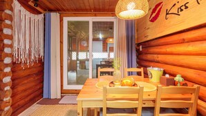 A wooden cabin interior with a dining table, chairs, a woven light fixture, and a glass door leading outside. - Pocheon Arumdri Pension (Pocheon)