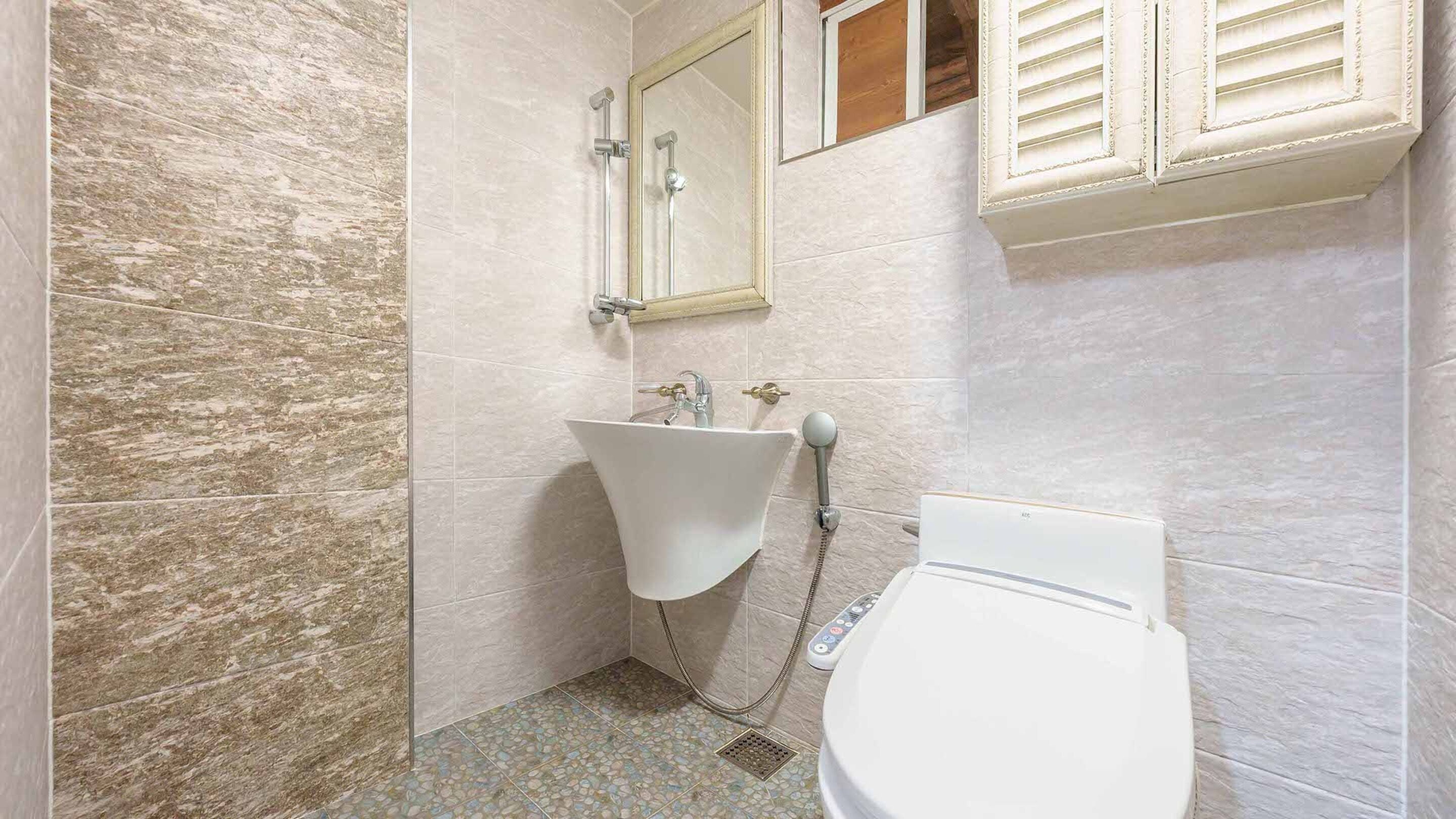 A bathroom with a white sink, a mirror, and a toilet.