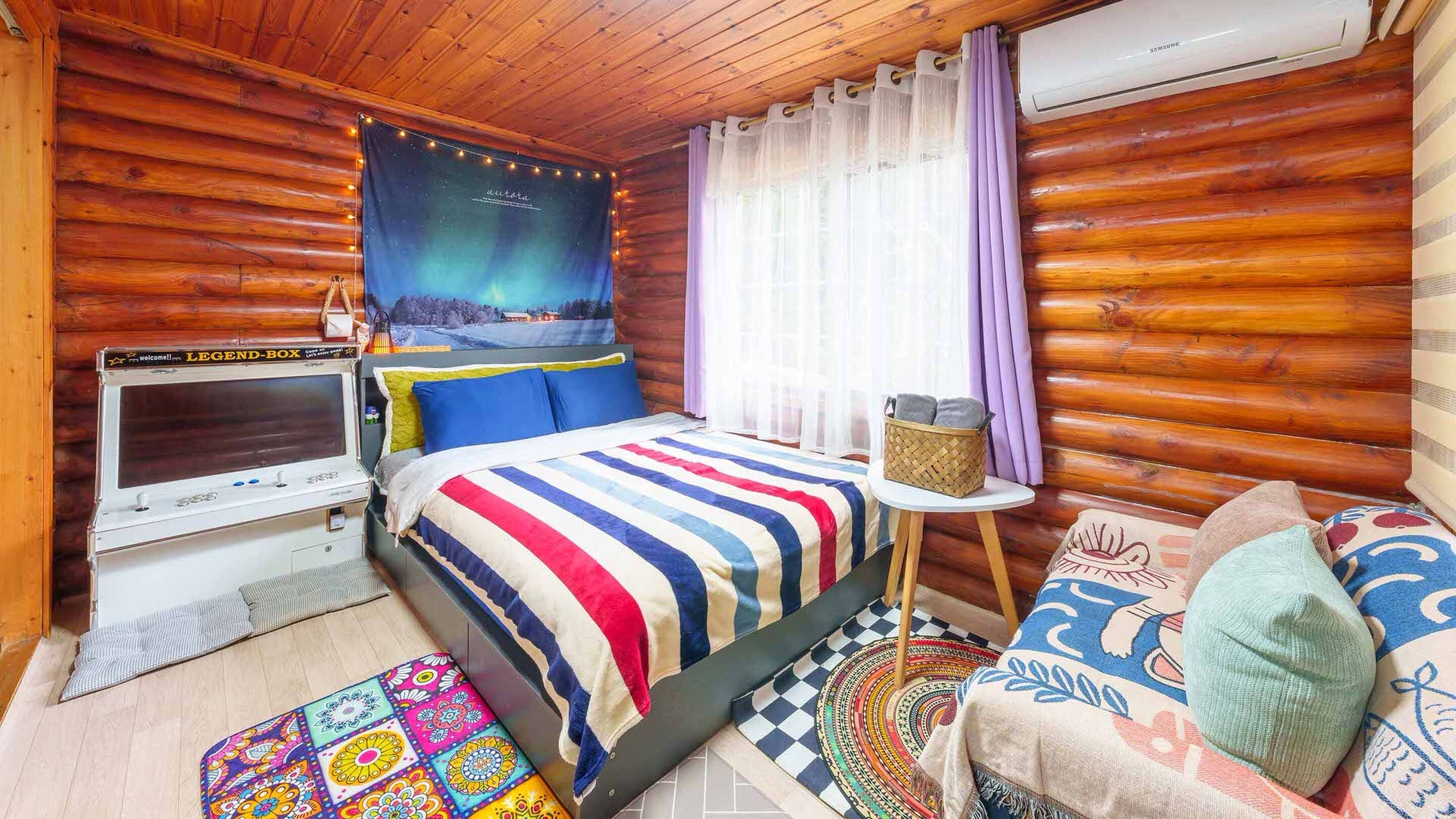 Une chambre confortable dans un chalet en rondins, avec un lit, une télévision et une fenêtre avec des rideaux.