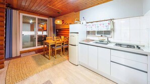 A cozy kitchen with a wooden interior, a dining area with a table and chairs, and a refrigerator. - Pocheon Arumdri Pension (Pocheon)