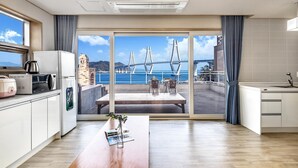 A modern kitchen with a view of a bridge and sea. - Geoje Healing Pension (Geoje)