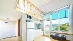 A modern kitchen with a built-in microwave, refrigerator, and wooden staircase. - Tongyoung Seychelles Poolvilla (Tongyeong)