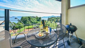 A balcony with a table set for two, a grill, and bottles of beverages. - Tongyoung Seychelles Poolvilla (Tongyeong)