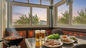 Comedor con vistas a árboles y un edificio a través de amplios ventanales.