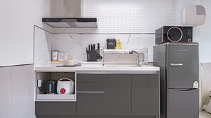 Una cocina moderna con horno integrado, cafetera y refrigerador.