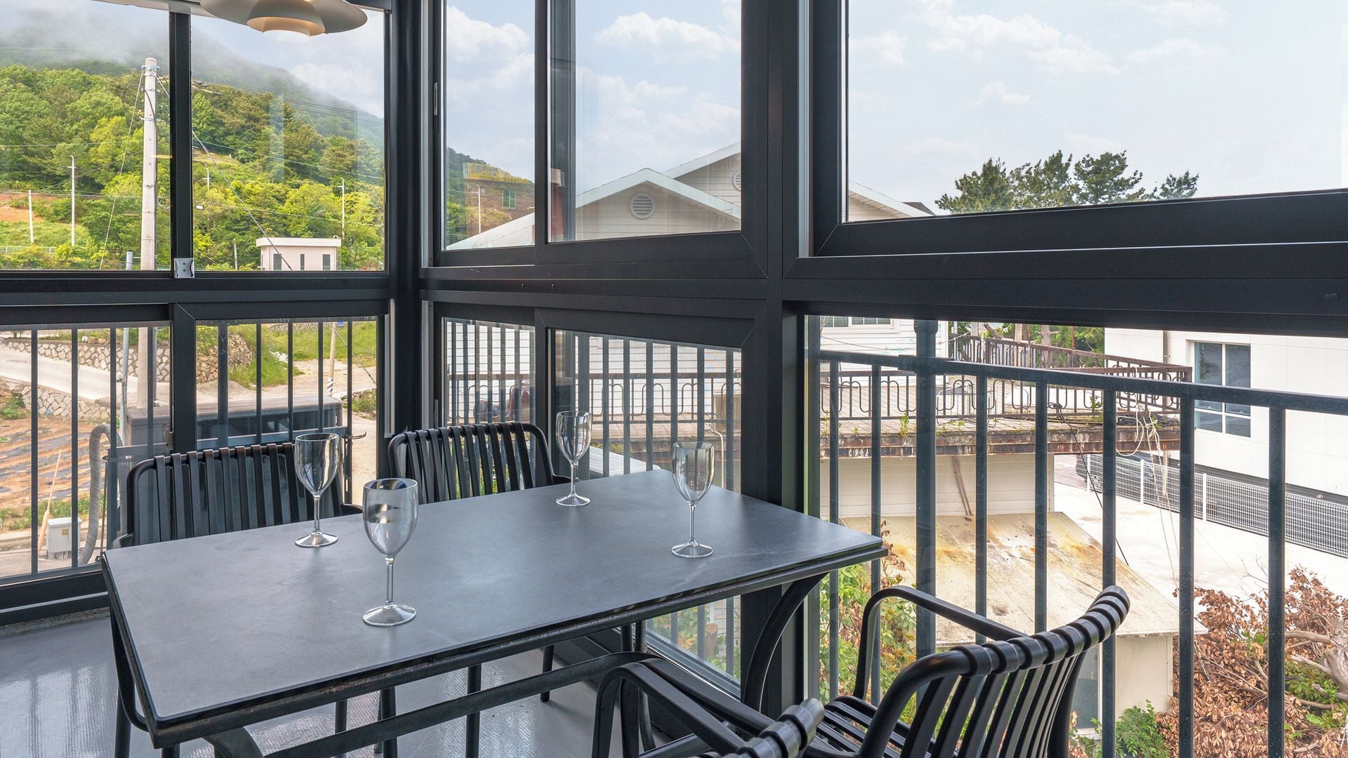 A restaurant with a table and chairs, large windows, and a view of the surrounding area.