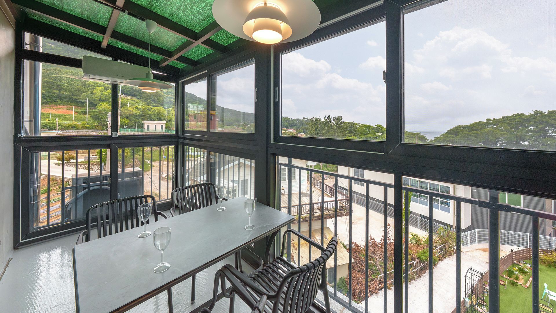 Un restaurante con terraza, ventanas amplias y vistas al paisaje circundante.