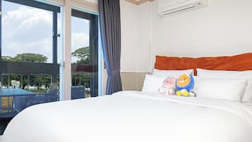 A hotel room with a large bed, a view of the outdoors, and an air conditioning unit on the wall.