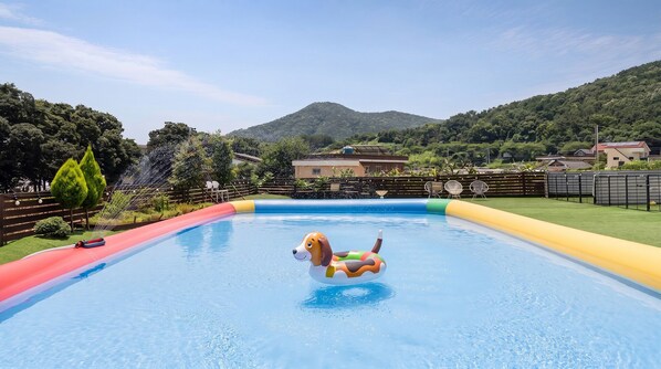 A swimming pool with a slide and inflatable dog floatation device.