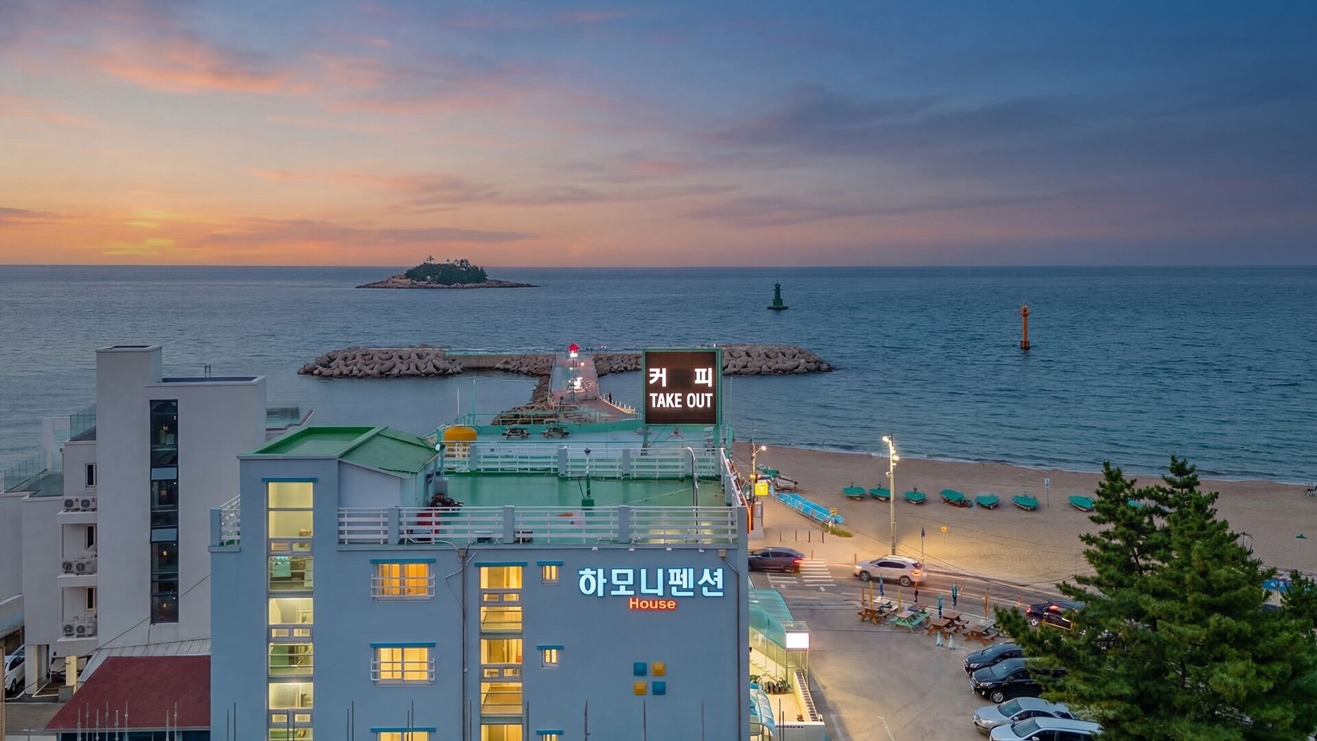 Um hotel à beira-mar com vista para o mar, uma placa com a inscrição 'TAKE OUT' e um edifício com a inscrição 'House'.