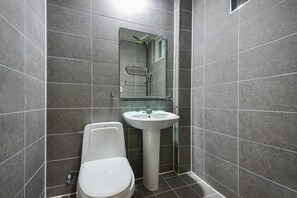 A modern bathroom with a white toilet, a pedestal sink, and a glass shower enclosure. - Samcheok Healingcamp Pension (Samcheok)