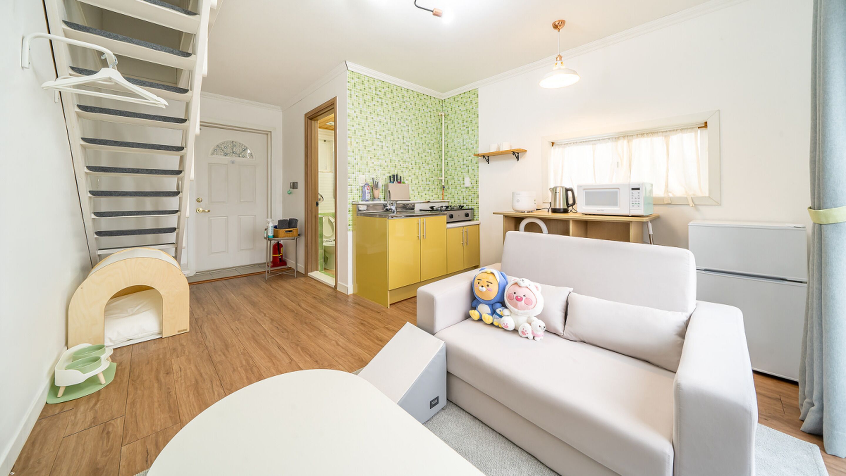 A compact living space with a kitchenette, a dining area, and a small bathroom.