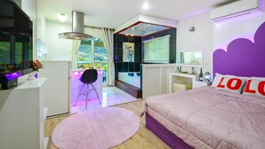 Et moderne soveværelse med seng, skrivebord og udsigt til en jacuzzi.