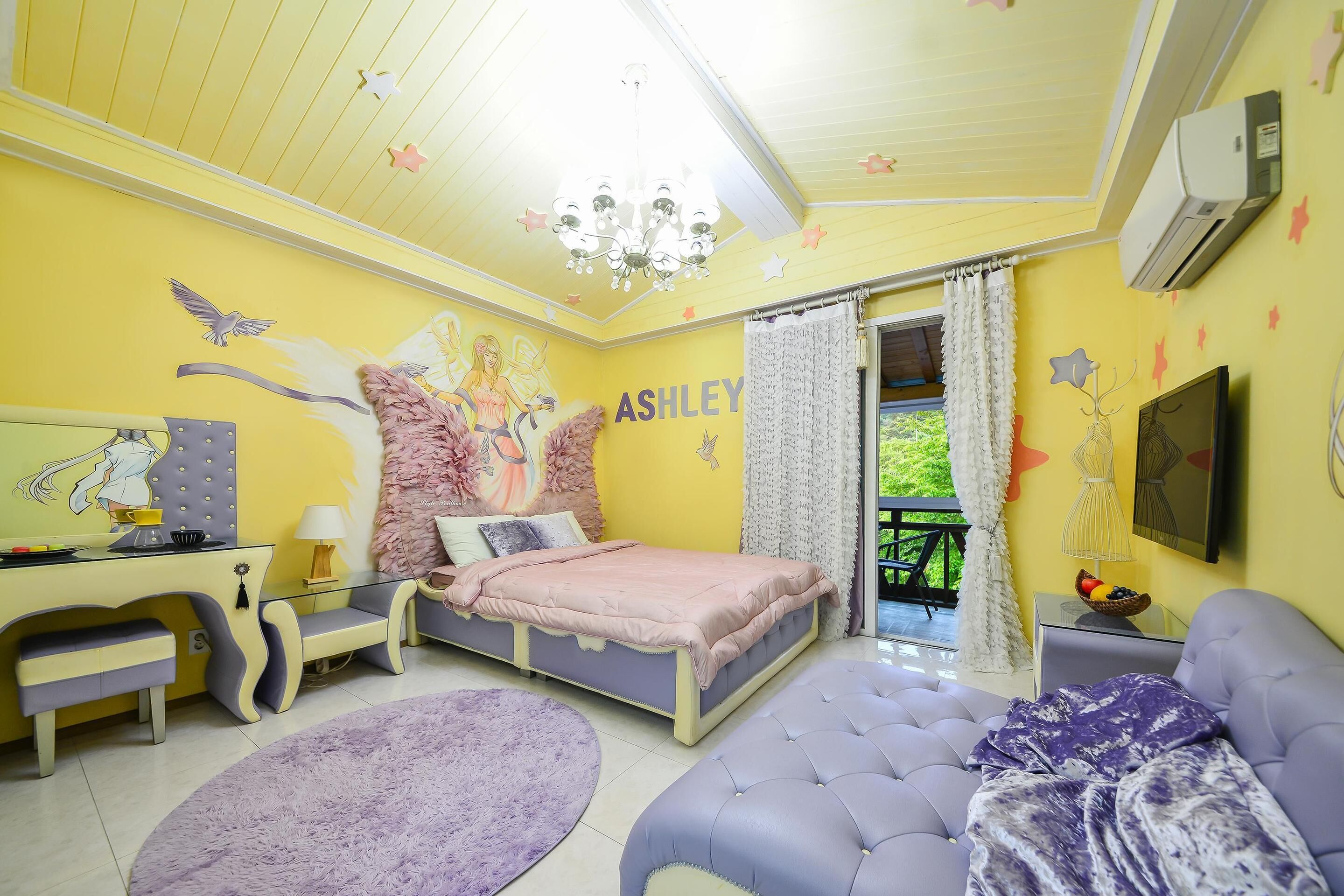 A bedroom with a bed, a desk, a chair, a sofa, and a window with curtains.