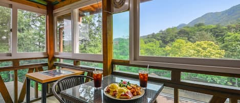 Comedor con una mesa preparada para dos, un plato de comida y dos bebidas.