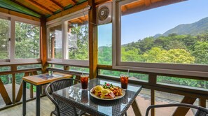 Uma área de refeições com uma mesa posta para dois, um prato de comida e duas bebidas.