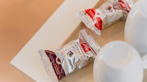 Two coffee packets and a white cup on a table. - Yeosu Dangdangi Dog Family Pension Gold (Yeosu)