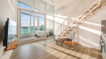 Enjoy a spacious living area with a balcony offering a view of the sky and distant landscape, perfect for relaxation and entertainment.