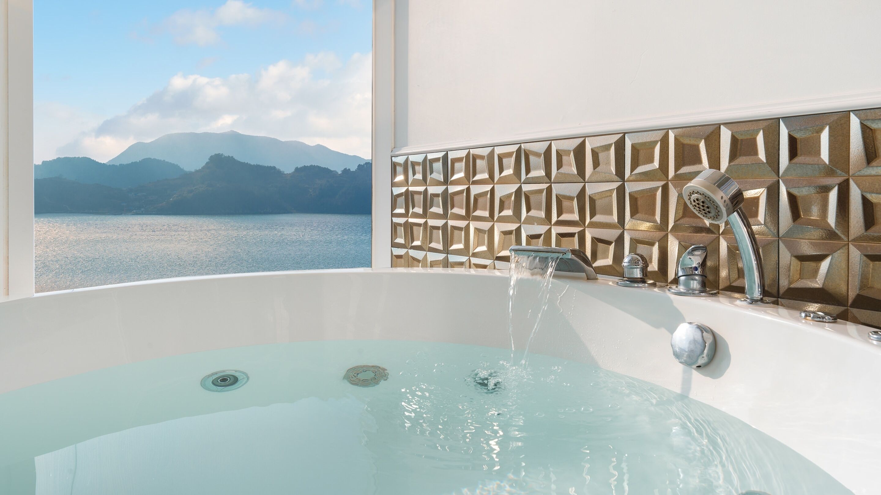 Une baignoire avec vue sur les montagnes et un lac.