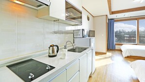 A modern kitchen with a built-in stove, sink, and window above the counter.