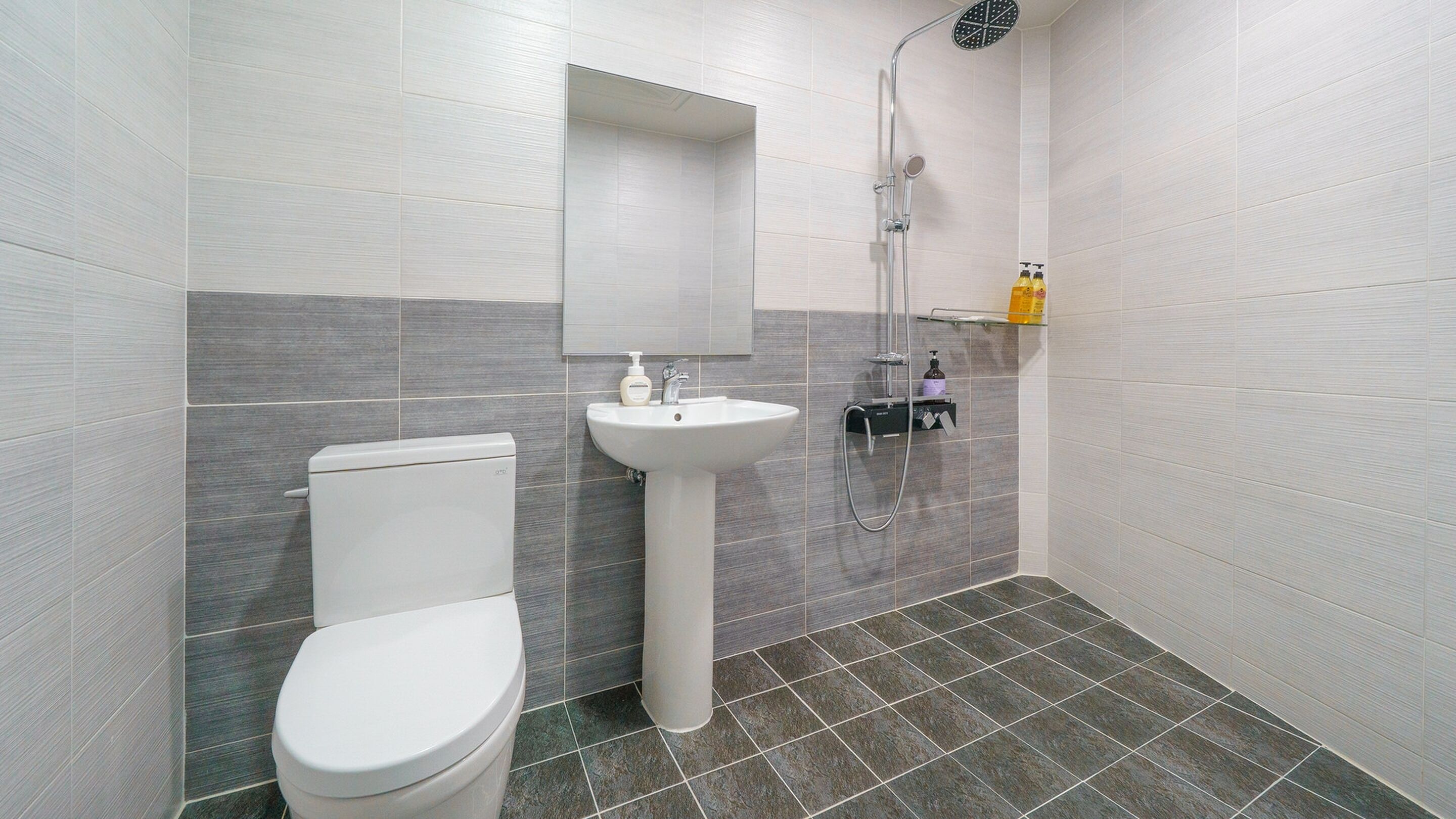 Un bagno moderno con WC, lavandino e doccia.