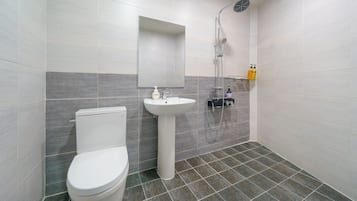 Un bagno moderno con WC, lavandino e doccia.
