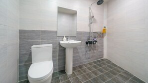 Een moderne badkamer met toilet, wastafel en douche.