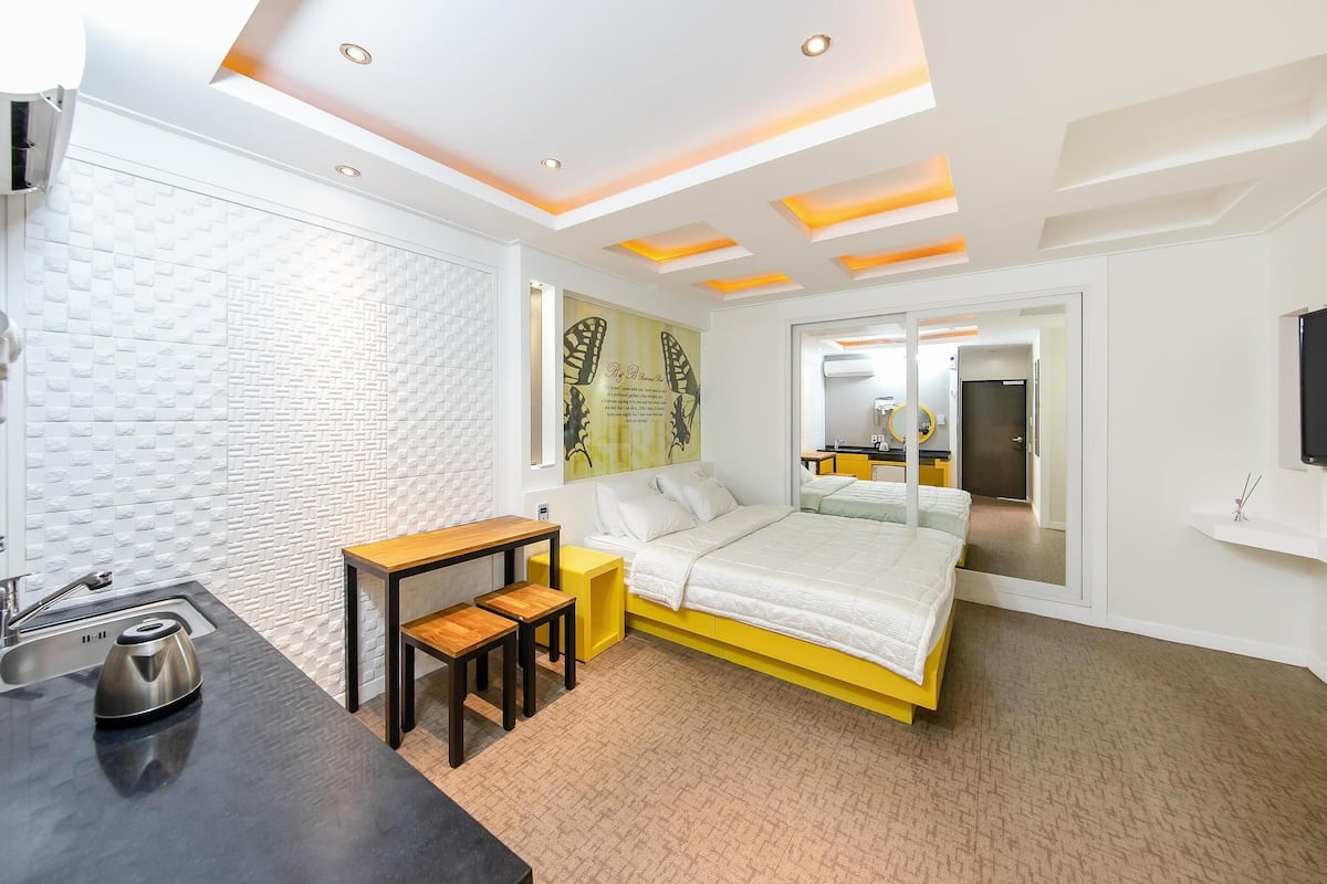 Une chambre à coucher moderne avec un lit, une table de chevet et un miroir.