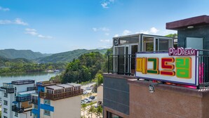 A hotel with a view of a lake and mountains. - Nami Island Pig Dream Spa Pension (Gapyeong)