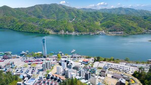 A coastal town with a marina, a tall observation tower, and a mix of residential and commercial buildings. - Nami Island Pig Dream Spa Pension (Gapyeong)