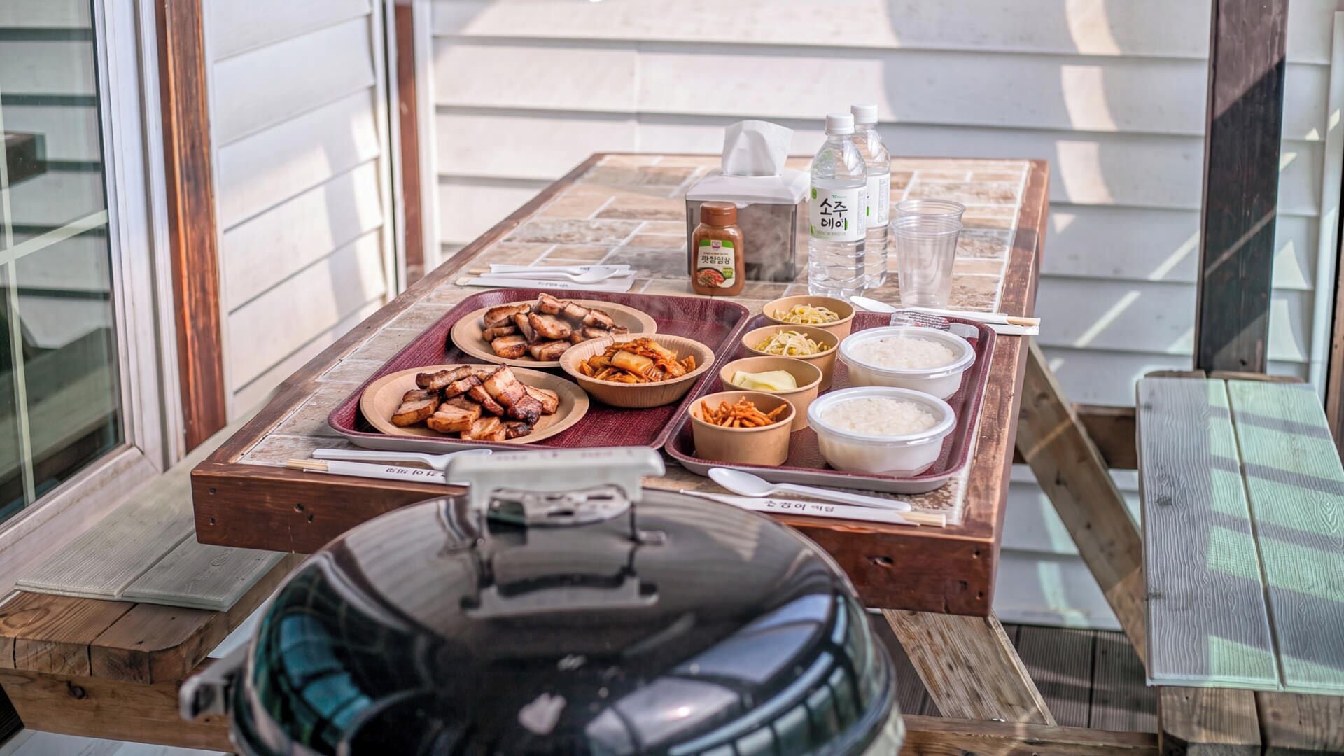 A dining table with various dishes, condiments, and a water bottle.