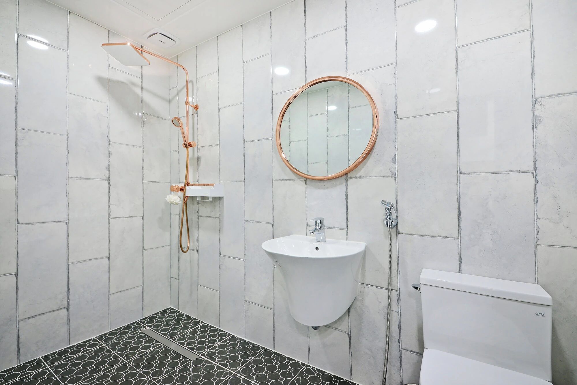 Une salle de bain avec une douche, un lavabo et des toilettes.