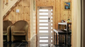 A wooden interior with a checkered chair, a door with a light switch, and a table with items on it. - Gapyeong Twelve Pension (Gapyeong)