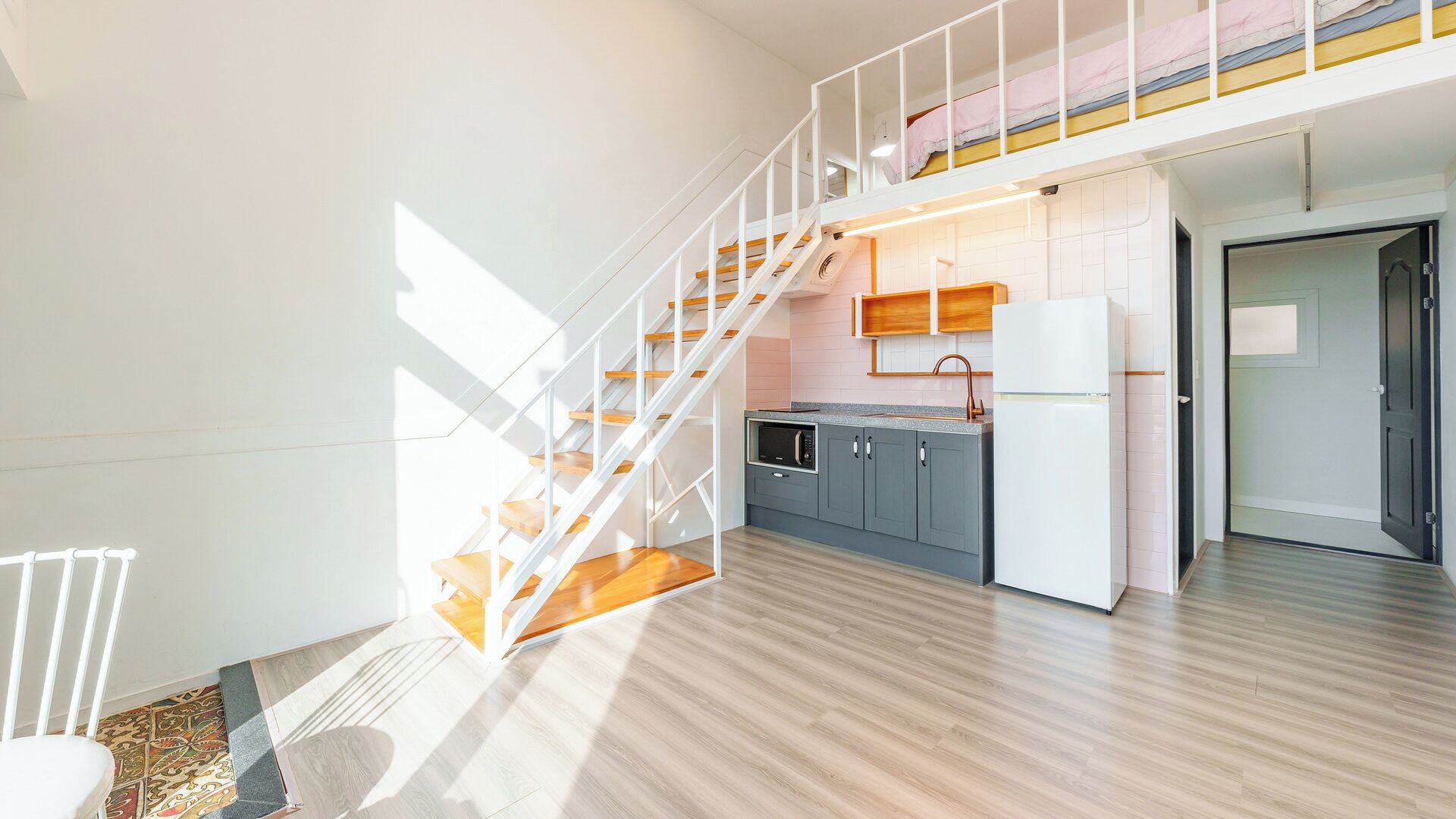 A modern kitchen with a built-in microwave, grey cabinets, and a white refrigerator.