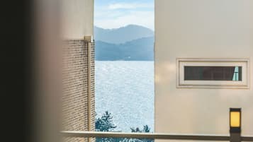 Habitació amb vista a un llac i muntanyes.
