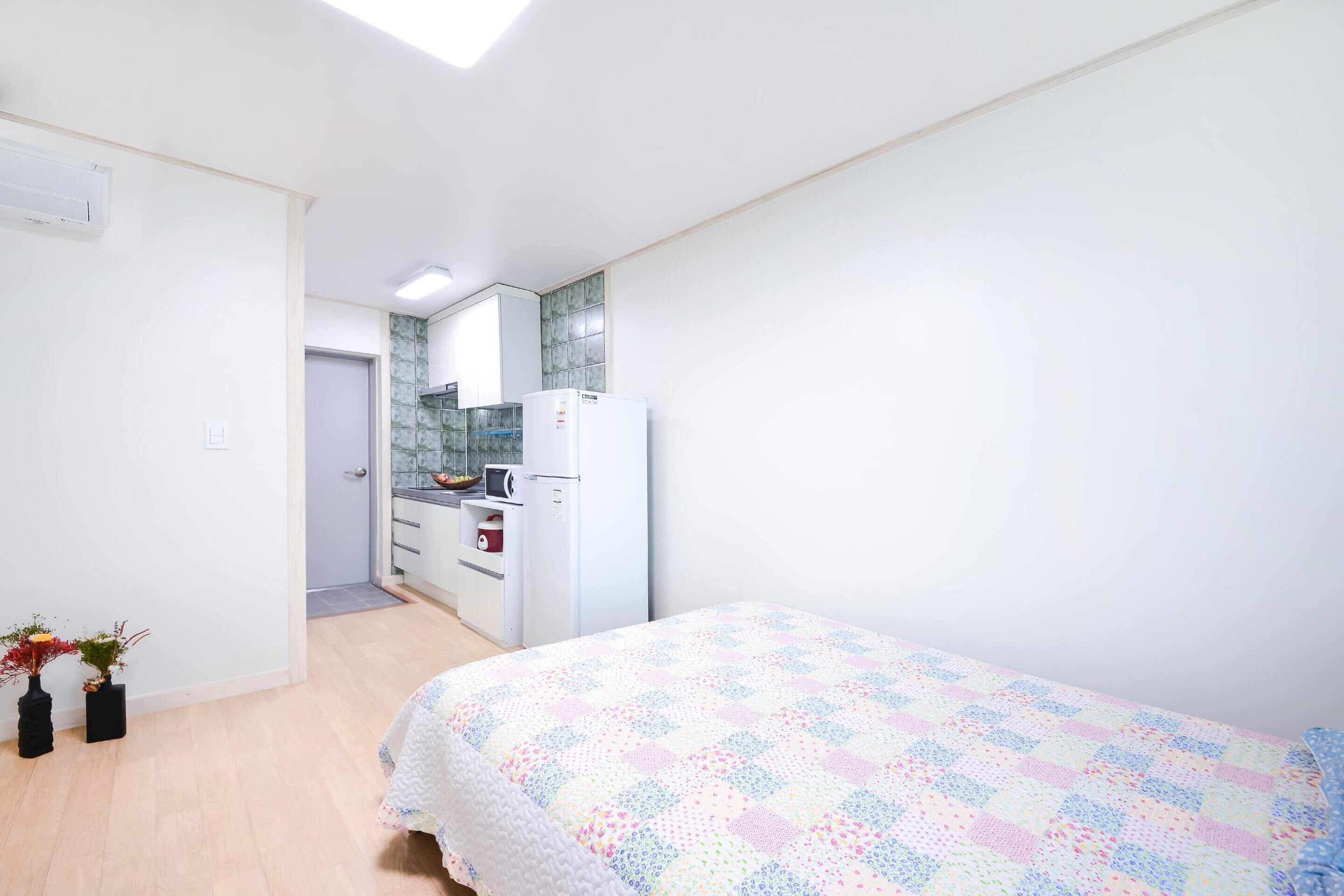 Une chambre comprenant un lit, un coin cuisine et une salle de bain.