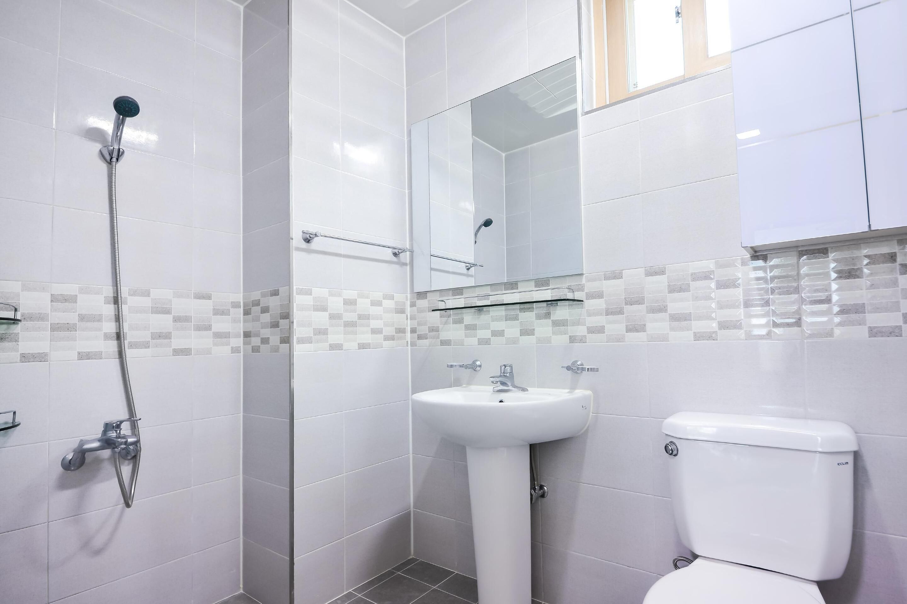 Un baño con ducha, lavabo e inodoro.