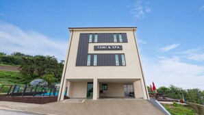 A modern building with a sign reading "TOMI & SPA". - Buan Tomynspa Pension (Buan)