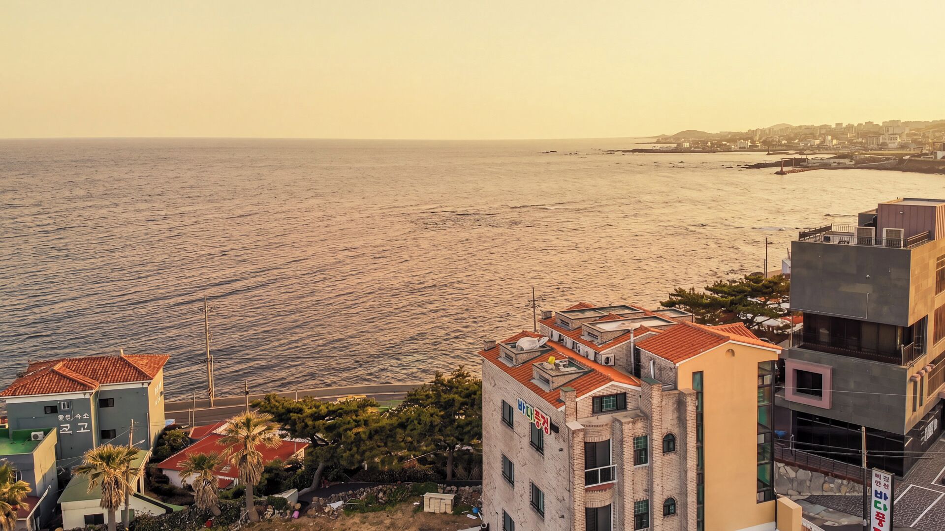 Un paysage urbain côtier avec des bâtiments, une plage et un ciel dégagé.
