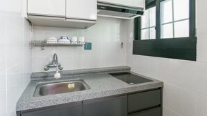 Eine moderne Küche mit Granit Arbeitsplatte, Edelstahlspüle und integrierter Dunstabzugshaube.